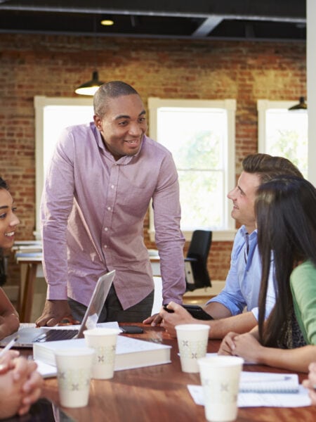 Male Boss Addressing Office Workers At Meeting