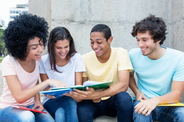 group of people looking at book outdoors