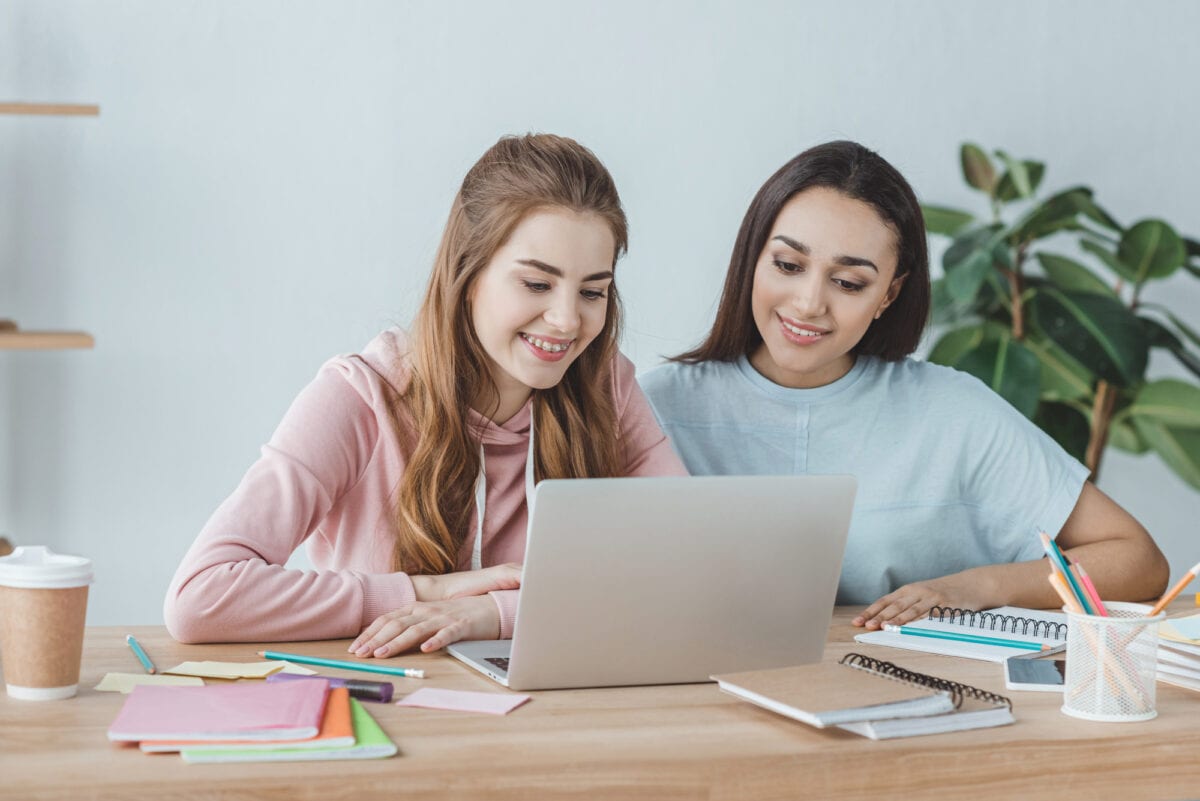 two women in front of laptop smiling